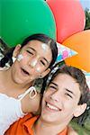 Portrait of a boy with his sister wearing birthday hats and smiling