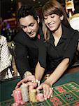 Mid adult man with a young woman placing gambling chips on a gambling table