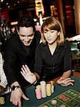 Mid adult man and a young woman gambling in a casino