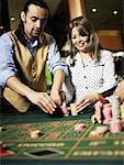 Casino worker arranging gambling chips for a young woman in a casino