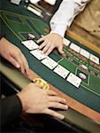 Mid vue en coupe d'un travailleur de casino traitant des cartes à jouer sur une table de jeu