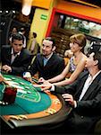 Four people playing blackjack in a casino