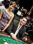 Mid homme adulte jeu dans un casino et une jeune femme debout à côté de lui