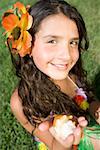 Portrait of a girl holding a conch shell and smiling