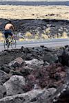 Rear view of a man riding a bicycle on the road, Kona Coast, Big Island, Hawaii Islands, USA