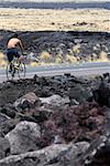 Rückansicht eines Mannes mit dem Fahrrad auf der Straße, Kona Coast, Inseln Big Island, Hawaii, USA