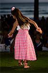 Rear view of a teenage girl hula dancing in a lawn