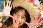 Portrait of a girl wearing a straw hat and sticking her tongue out