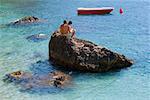 Touristen sitzen auf einem Felsen, Capri, Kampanien, Italien