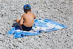 Vue arrière d'un petit garçon assis sur une couverture, Capri, Campanie, Italie