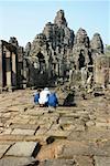 Rear view of three tourists at a temple, Angkor Wat, Siem Reap, Cambodia