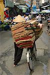 Rear view of a man selling rugs in a market, Hanoi, Vietnam