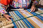 Mid section view of a woman weaving in a loom, Aguanacancha, Peru