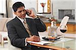 Man Using Cellular Phone at Dinner Table