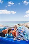 Man and woman in car by sea.