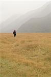 Man in Valley by Mountains, Eglinton Valley, Milford Road, Fiordland National Park, New Zealand