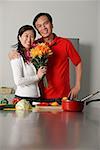 Mature Couple in Küche, umarmen, Frau mit Blumenstrauß
