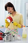 Femme dans la cuisine, nettoyage des marmites et casseroles