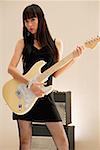 Young woman playing electric guitar