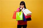 Young woman holding shopping bags close to herself, smiling