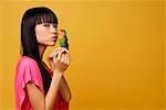 Jeune femme avec inséparable sur sa main, embrasser des oiseaux