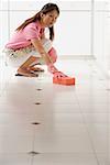 Woman cleaning floor with big pink sponge