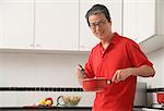 Mann in der Küche Kochen mit Topf, Blick in die Kamera