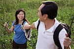 Man and woman hiking outdoors, nature, holding hands, looking at each other