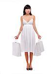 Young woman wearing white dress and holding white shopping bags