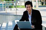 A man uses his laptop outdoors