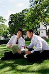 Two men read the newspaper in the park