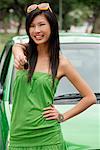 A young woman in a green dress with a green car