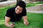 A man listens to music on a mp3 player in the park