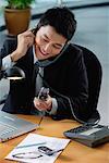 A man sits at his desk with lots of phones