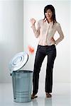 A woman throws something in the rubbish bin
