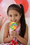 A young girl at a party with balloons