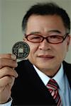 A man holds out a Chinese coin