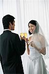 A newlywed couple hold out their champagne glasses for a toast