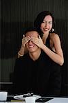 A woman covers her boyfriends eyes as she prepares to surprise him with dinner