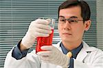 Scientist examining container of fluid