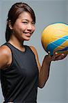 Jeune femme avec volleyball souriant à la caméra