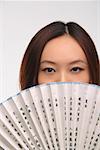 Young woman with fan looking at camera