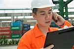 Man with hard helmet looking at clipboard