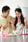 Young woman being surprised with birthday cake