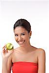 Young woman smiling at camera holding apple