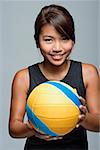 Young woman with volleyball smiling at camera