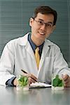 Scientist examining jar with plant samples
