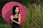 Femme dans l'herbe longue avec parasol