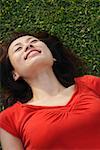 Woman smiling, lying on grass