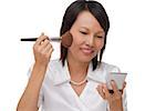 Woman applying make-up  while looking into compact mirror